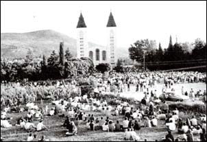 Folla in preghiera durante la celebrazione della Santa Messa sul Piazzale di Medjugorje nel 1984, quando ancora non era stato eretto l'altare dietro la chiesa.